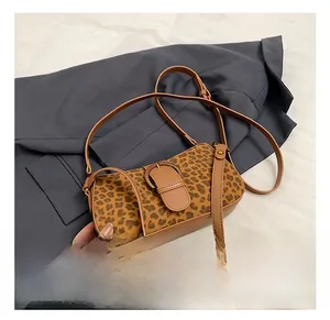 Detail shot of vintage leopard print suede handbag with leather buckle on grey blazer background
