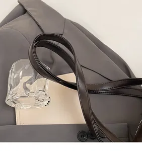 Detailed view of dark brown leather long shoulder strap with polished smooth texture