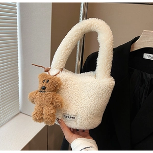 Détail du sac seau en peluche crème avec texture laine d'agneau et breloque ourson