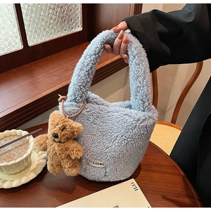 Détail du sac seau en laine d'agneau bleu clair avec un joli pendentif ours marron