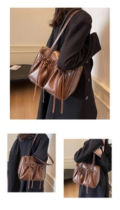 Detail of dark brown vintage tote bag with dual front pockets and drawstring accents