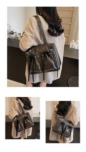 Detail of vintage black tote bag featuring delicate ribbon bows and dual front pockets