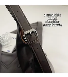 Close-up of adjustable gunmetal buckle on dark brown PU leather shoulder strap