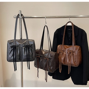 Detailed shot of pleated vintage shoulder bags in black, dark coffee, and light brown colors