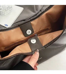 Detail of deep brown leather tote bag showing interior lining and magnetic buckle
