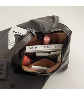 Detail view of the spacious interior of a brown leather tote bag with daily essentials