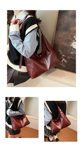 Detail of dark red leather tote bag showing smooth texture and wide shoulder strap