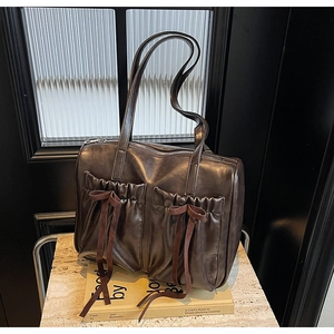 Detailed shot of vintage brown leather tote bag featuring elegant bow-tied front pockets