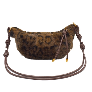 Close-up of leopard faux fur crescent bag with knotted leather strap and gold ring