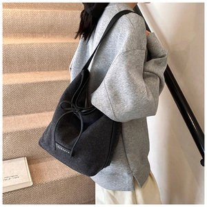 Detail of grey corduroy tote bag with drawstring bow and textured ribbed fabric finish