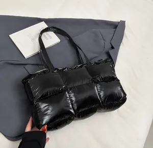Detail showing high-gloss quilted black tote bag with fluffy texture on a blazer