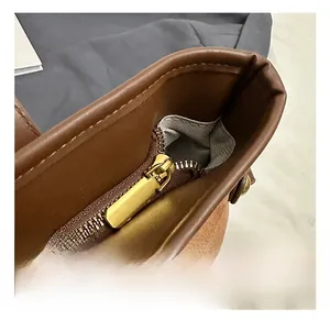 Gros plan détaillé du sac cabas en cuir marron et daim avec fermeture éclair dorée de qualité