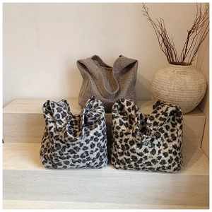 Three leopard print and grey knit tote bags displayed on a neutral aesthetic stage