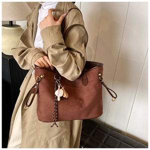 Détail du grand sac cabas en daim marron foncé avec pendentif baseball et métal doré