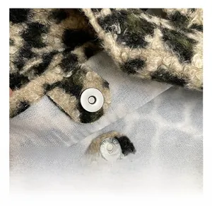 Macro shot of silver magnetic buckle on leopard print plush tote bag with plush texture