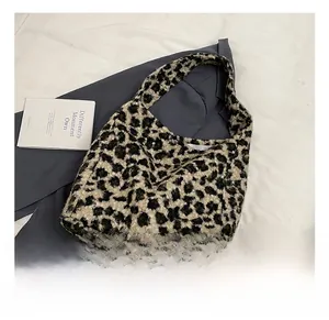Detail showing high-capacity leopard print tote bag with soft suede texture and wide strap