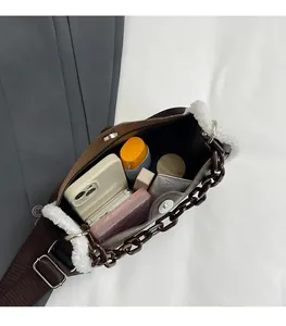 Detailed top view of brown fabric crossbody bag with white fur trim and daily essentials