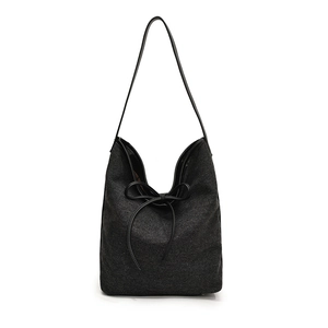 Chic black denim shoulder tote bag with a minimalist bow design and sleek leather strap