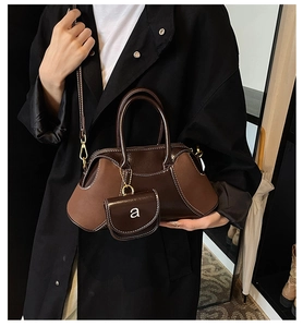Dettaglio della borsa vintage marrone scuro con cuciture a contrasto e mini pochette rimovibile