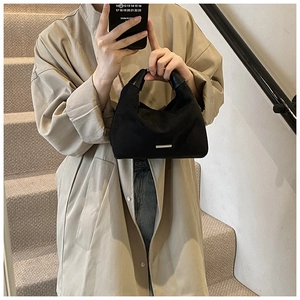 Detail einer schwarzen Hobo-Tasche mit Ledergriff und silbernen Metallakzenten