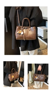 Close-up of vintage dark brown tote bag with twist lock and decorative tassel detail