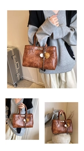 Detail of vintage brown tote bag featuring decorative stitching and baseball charms