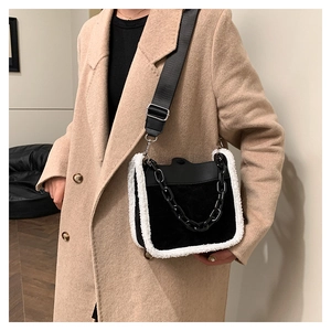 Close-up of black crossbody bag featuring white faux shearling trim and chain detail