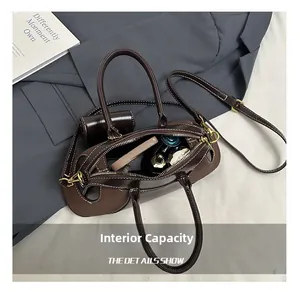 Internal capacity of the dark brown leather Boston bag showing makeup and perfume storage