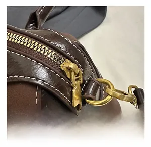 Detail of vintage gold hardware and dual-tone brown leather stitching on a mini bag