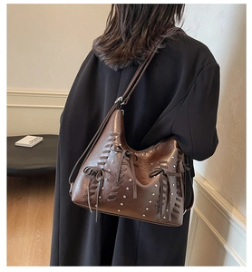 Dettaglio borsa tote in pelle PU marrone scuro con cinturini intrecciati e rivetti argento