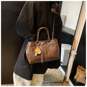 Detail of vintage brown leather tote bag with round handles and adjustable strap