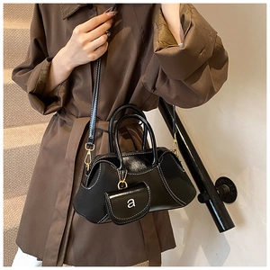 Detail of vintage black leather satchel bag with mini coin purse on brown coat