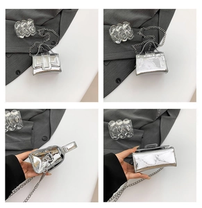 Macro detail of silver mirror mini bag showing chain strap and glossy metallic texture