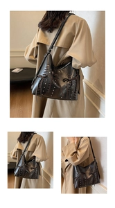Dettaglio della borsa hobo con borchie metalliche, lacci in pelle e fiocco