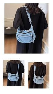 Detail view of light blue denim crossbody bag with multiple zippers for casual storage