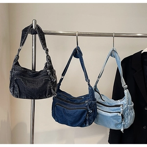 Three denim shoulder bags in black, dark blue, and light blue with multiple zip pockets