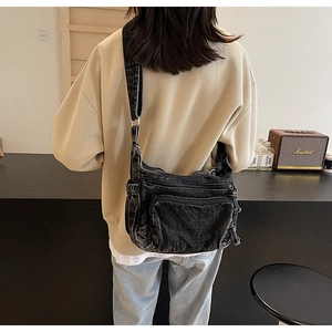 Detailed back view of a vintage washed denim crossbody bag with adjustable wide strap