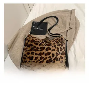 Détails du sac cabas en fausse fourrure léopard avec bandoulières en cuir noir sur fond beige