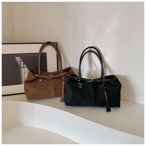 Detailed shot of brown and black matte suede tote bags with decorative metal buckles