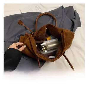 Macro shot showing internal capacity of large brown suede tote with toiletries