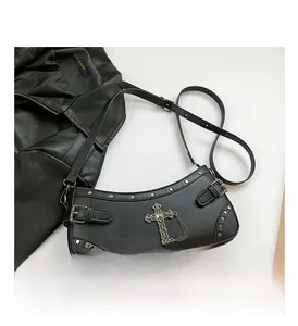 Close-up of black goth crescent shoulder bag with silver rivets and cross chain detail