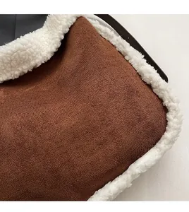 Detail of brown faux suede tote with plush white faux fur trim and black leather strap
