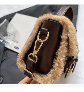 Detail of dark brown leather handbag with plush faux fur trim and gold metal buckle