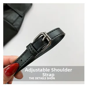 Detail of adjustable black PU leather shoulder strap with silver buckle and stitching