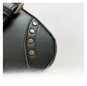 Close-up of black lychee-grain faux leather bag featuring decorative silver metal rivets