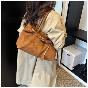 Brown suede tote bag styled with a beige trench coat for a vintage commuting look