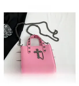 Close-up of pink punk handbag featuring silver metallic spikes and gothic cross pendant