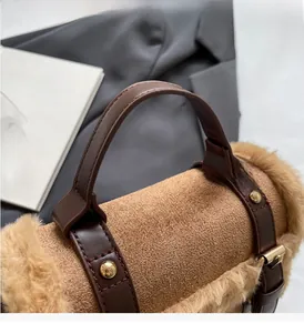 Close-up of brown suede handbag with plush faux fur trim and gold metal rivets