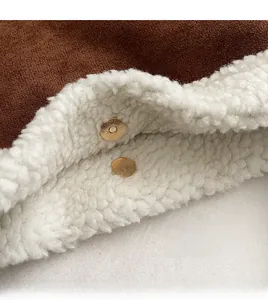 Detailed macro view of the brown suede surface with plush lining and gold magnetic buckles