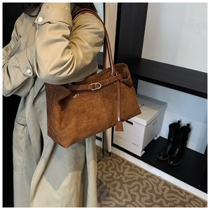 Detailed close-up of a large caramel matte tote bag featuring stylish metallic buckle strap